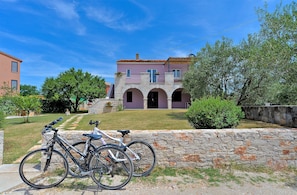 A building with a stone wall and a paved path leading to it.