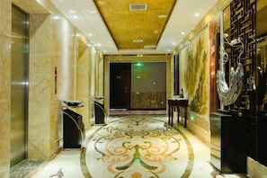 A hotel lobby with marble floors, a reception desk, and a large wall mural. - Jiu Long International Hotel (Mengcheng)