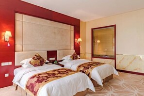 A hotel room with two beds, a large headboard, bedside lamps, a nightstand, and a large mirror. - Jiu Long International Hotel (Mengcheng)