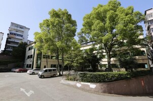 Un estacionamiento con autos, árboles y edificios.