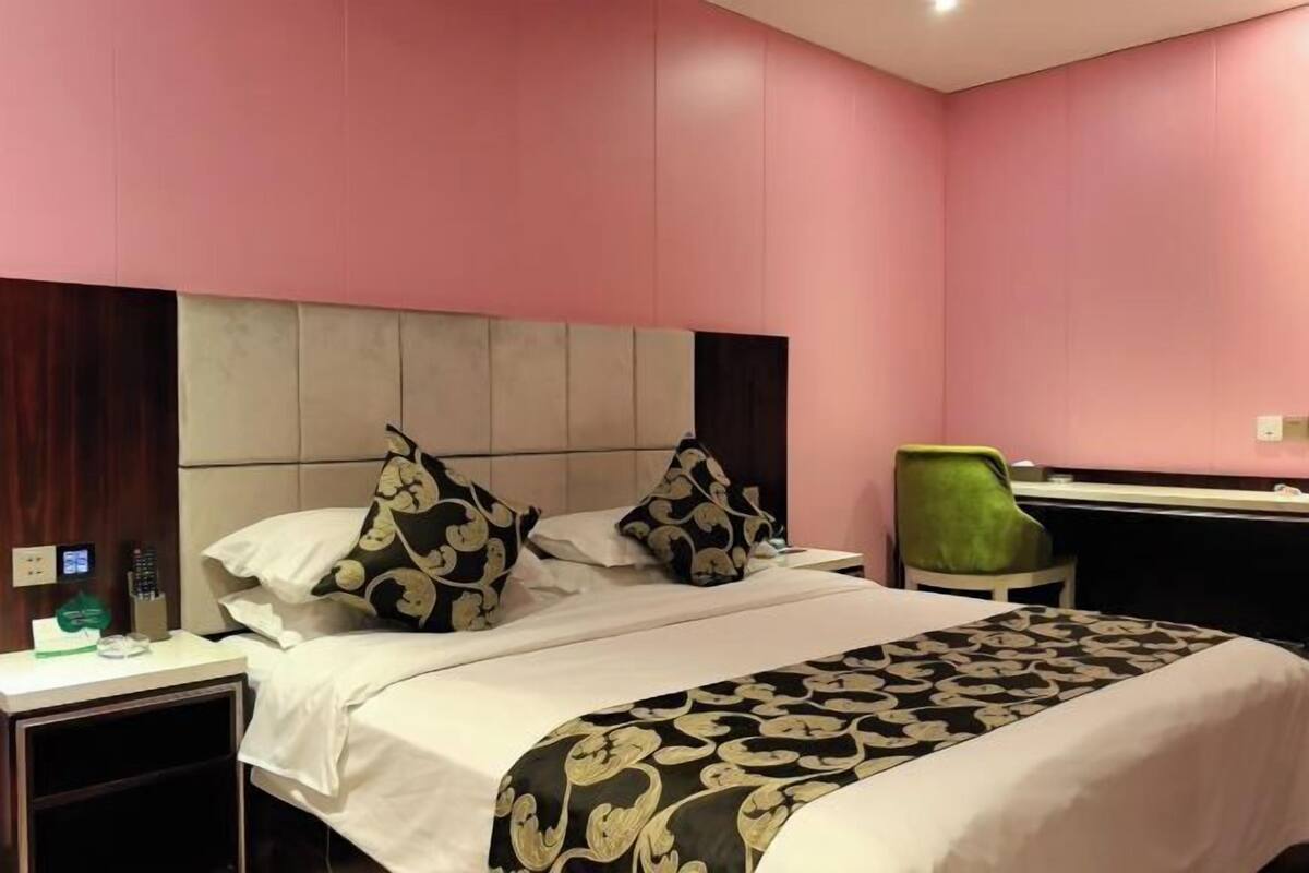 Une chambre d’hôtel avec un lit, un bureau et une chaise.