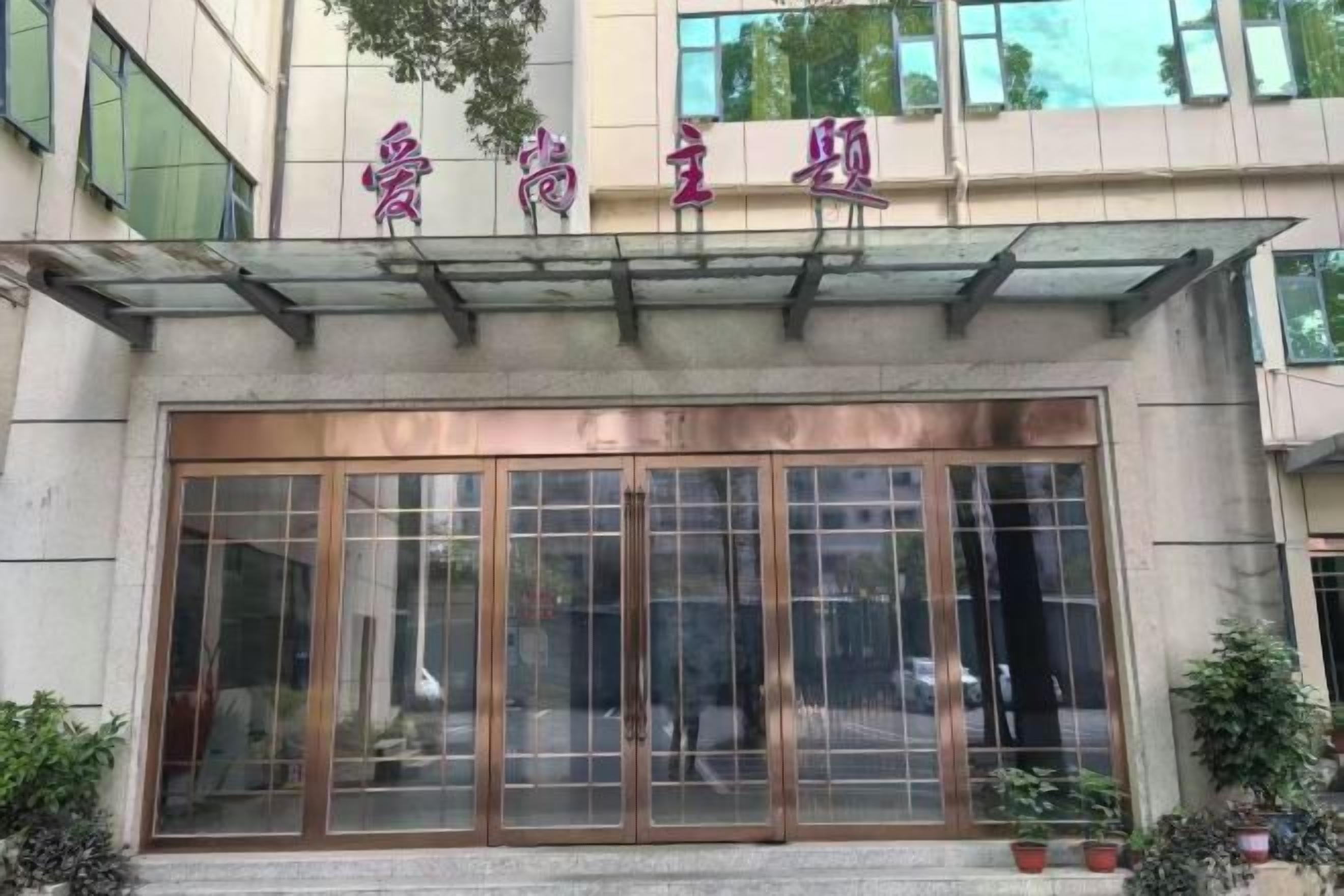 A building entrance with a large glass door and a sign above it.