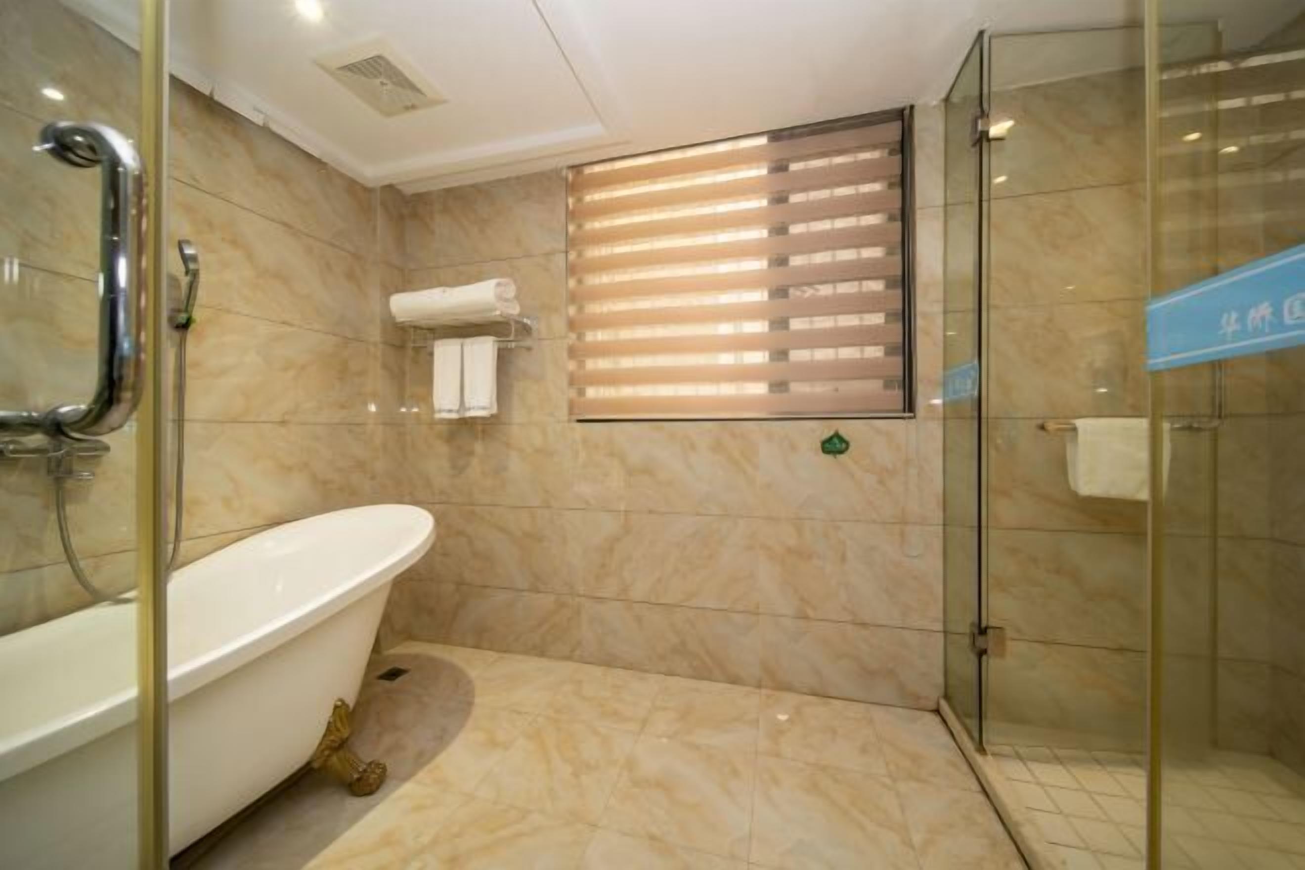 A bathroom with a freestanding bathtub, a glass shower enclosure, and a towel rack.