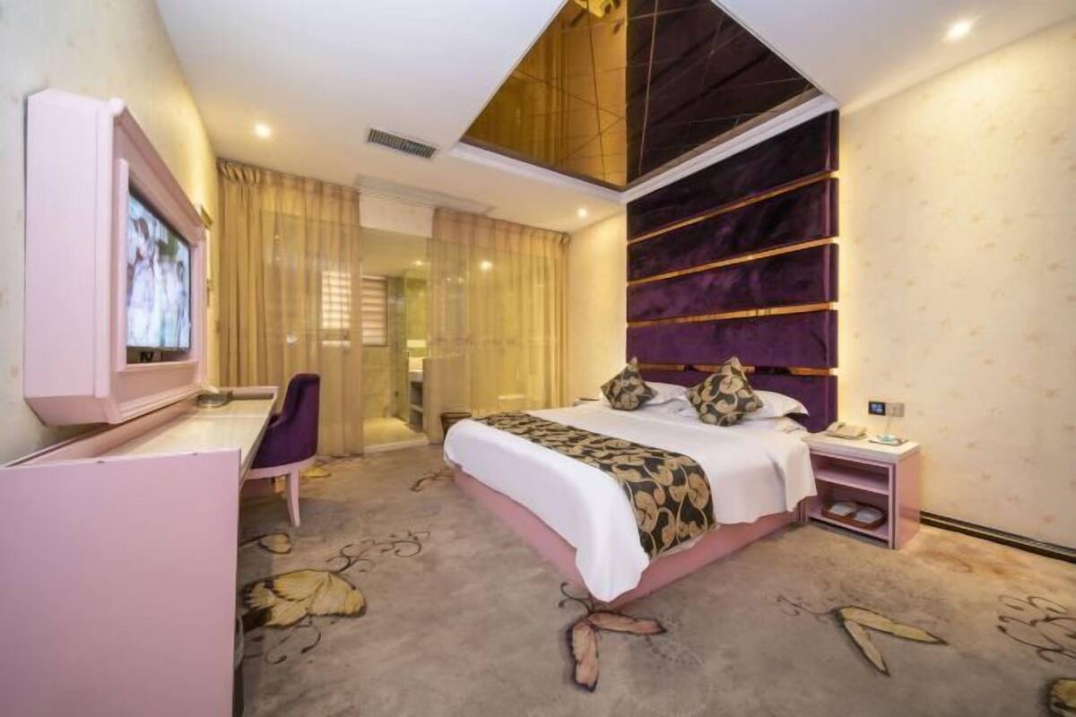 Une chambre à coucher moderne avec un lit, un bureau et un téléviseur.
