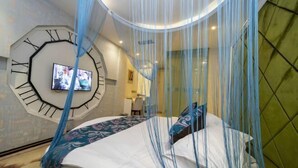A bedroom with a large clock on the wall, a bed with a canopy, and a television mounted on the wall.
