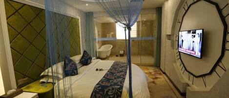A hotel room with a bed, a television, a clock, and a shower area.
