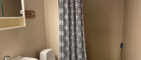 A bathroom with a white sink, a toilet, and a shower curtain with a black and white pattern.