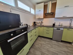A modern kitchen with a black microwave, a coffee maker, and a dishwasher.