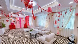 A modern living room with a patterned carpet, a sectional sofa, and a round coffee table. - Jinjiang Business Hotel (Yilan)