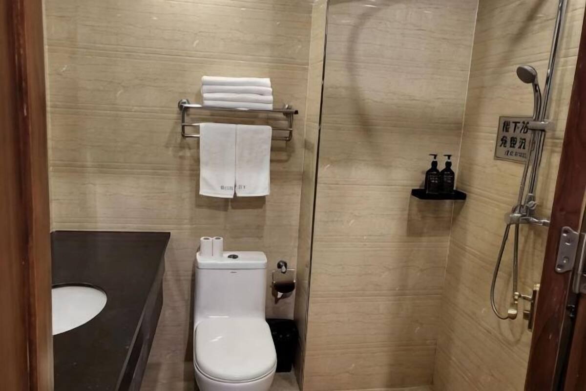 A bathroom with a toilet, sink, and shower.