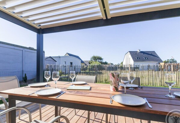 Enjoy al fresco dining on this patio, complete with a beautifully set table and a tranquil view of the surrounding neighborhood.