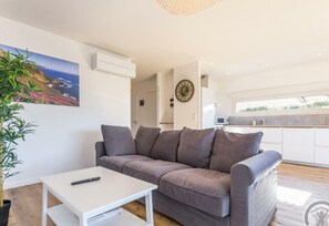 Relax in this stylish living room with a sofa, coffee table, and ocean views from the large window.