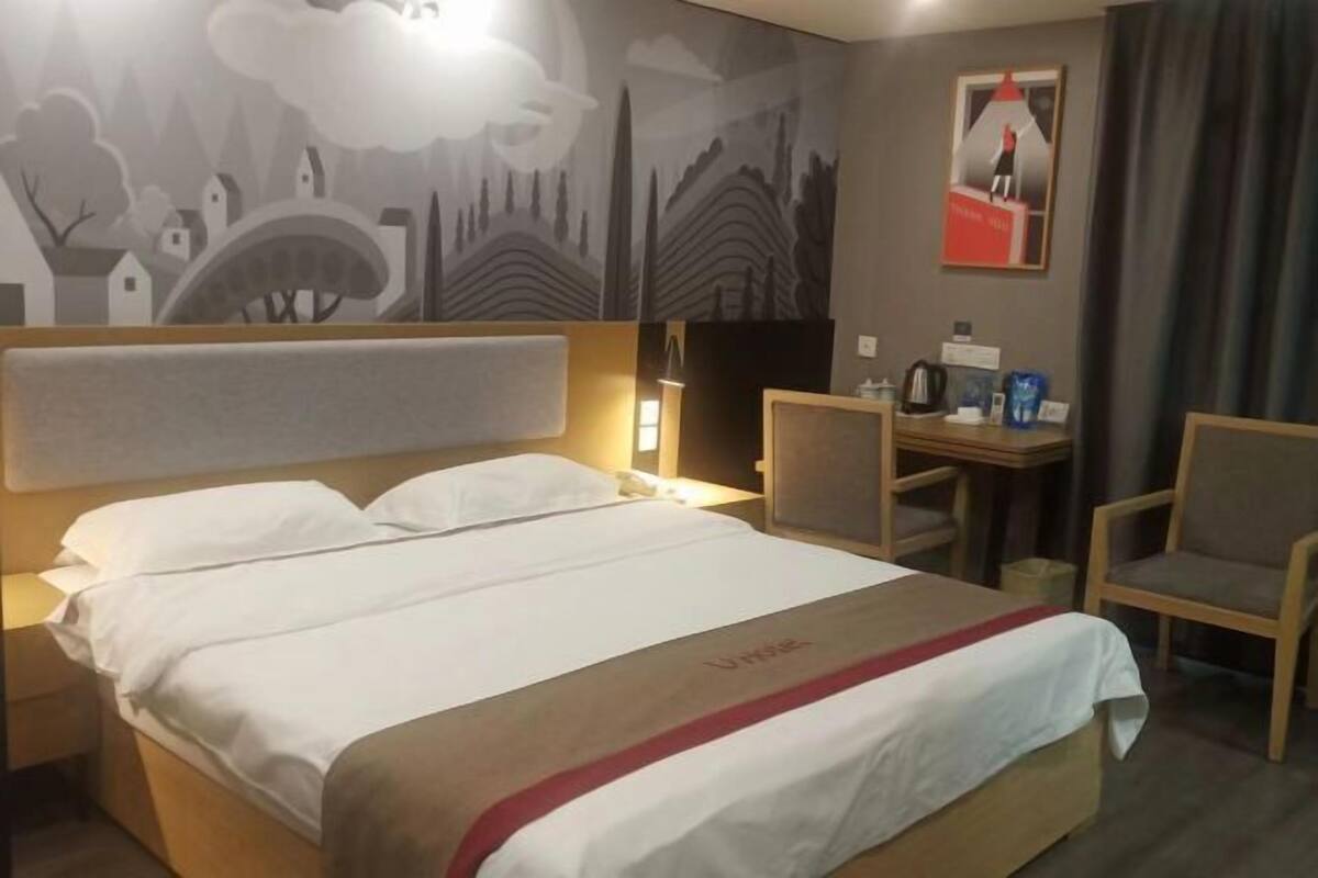 A hotel room with a bed, a desk, and a chair.