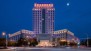 A multi-story hotel with a prominent entrance and illuminated signage. - Vienna International Hotel (Yushan Sanqing Square) (Yushan)
