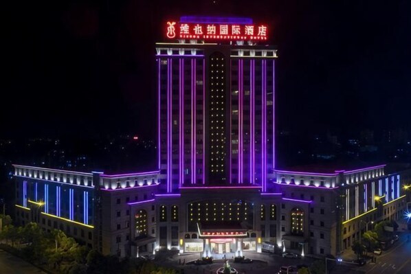 Un grand hôtel doté d’une entrée imposante, d’un éclairage vertical et d’une enseigne avec des caractères chinois.
