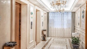 A hallway with a chandelier, a potted plant, and a patterned floor. - Vienna International Hotel (Yushan Sanqing Square) (Yushan)