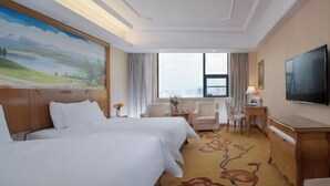 A hotel room with two beds, a desk, a TV, and a large window. - Vienna International Hotel (Yushan Sanqing Square) (Yushan)