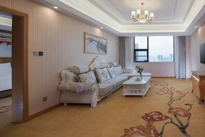 A hotel room with a sofa, a coffee table, a TV, and a large window with a city view. - Vienna International Hotel (Yushan Sanqing Square) (Yushan)