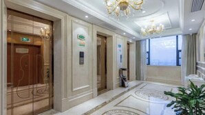 A hotel lobby with a marble floor, a chandelier, and a large window. - Vienna International Hotel (Yushan Sanqing Square) (Yushan)