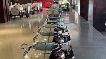A long buffet table with covered food serviceware.