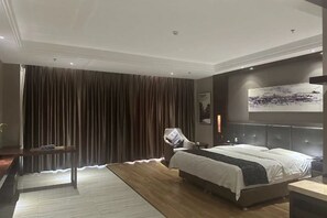 Een moderne slaapkamer met een groot bed, een bureau en een stoel.