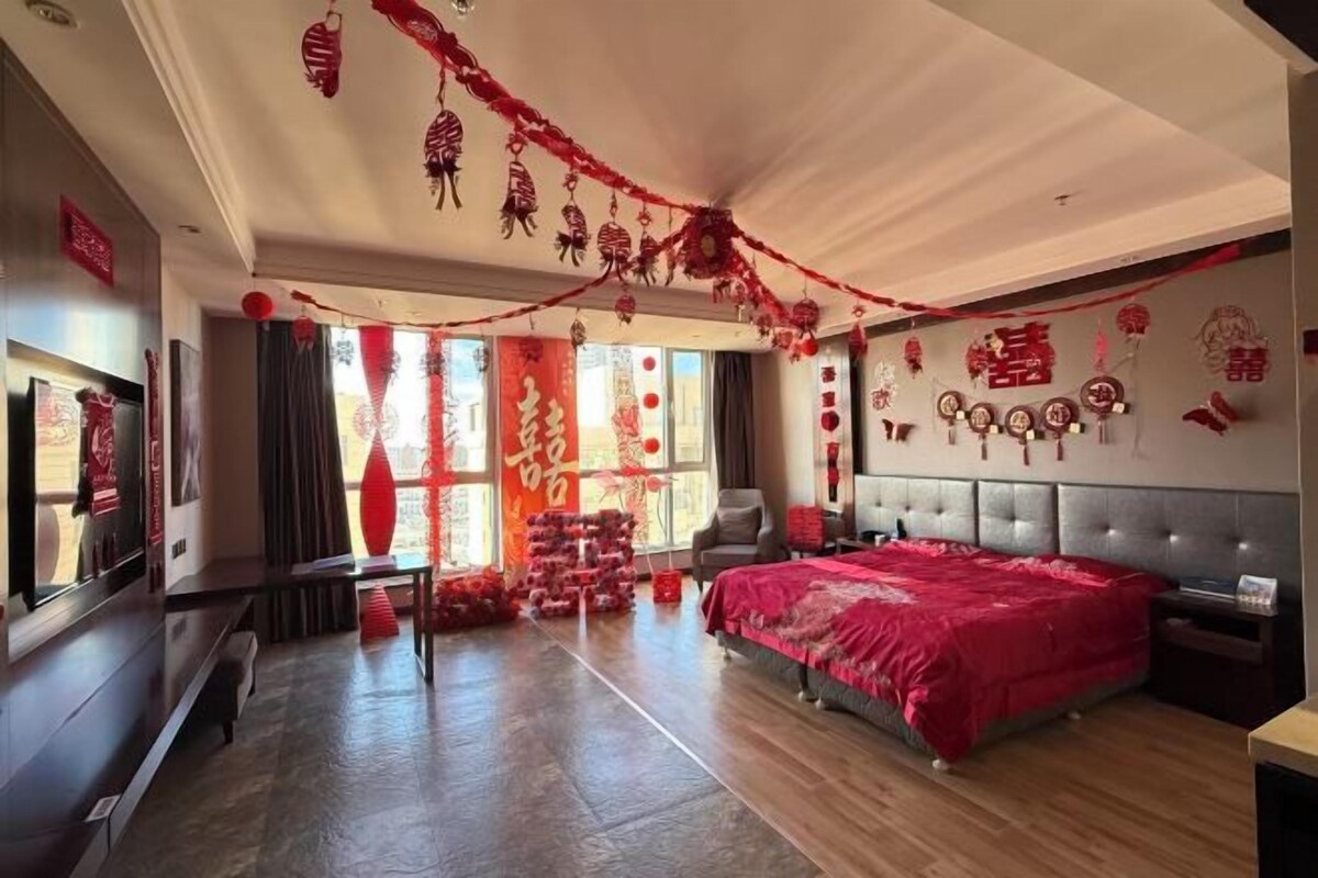 Ein geräumiges Schlafzimmer mit einem großen Bett, einem Fernseher und einer Sitzecke.