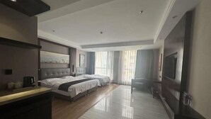 Une chambre d’hôtel avec un grand lit, un bureau, une télévision et une vue sur l’extérieur.
