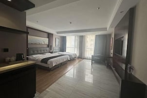 Habitación de hotel con una cama grande, un escritorio, televisión y vistas al exterior.