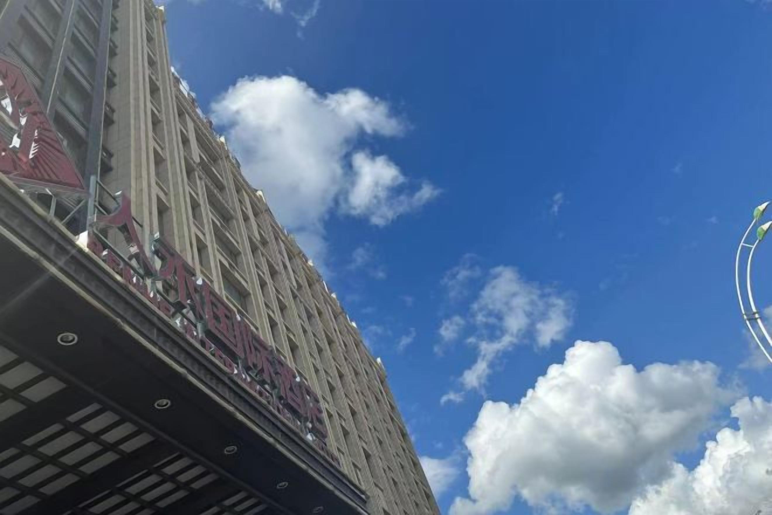 A tall building with a clear sky and clouds.