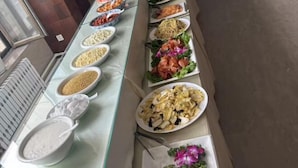 Un buffet proposant une variété de plats, notamment des pâtes, des salades et des viandes.