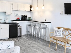 A modern kitchen with white cabinets, a coffee machine, and bar stools. - #208 "Sandy Schus" 1 BD + Sleeper, Modern,Pool (Isle of Palms)