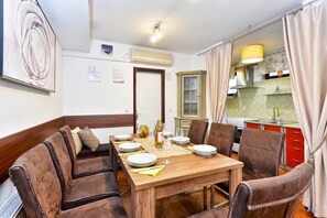 A dining area with a wooden table set for four, surrounded by leather chairs. - Twin Oasis Retreat With Pool & Spa (Sveti Ivan Zelina)