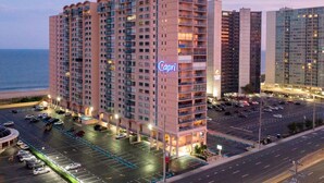 A high-rise hotel with a prominent "Capri" sign, multiple floors, and a parking lot in front.