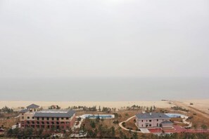 Un complexe hôtelier comprenant plusieurs bâtiments, un espace piscine et offrant une vue sur la plage.