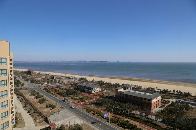 Un paisaje urbano costero con playa, edificios y cielo despejado.