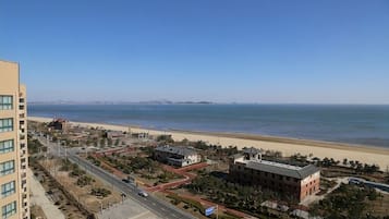 A coastal cityscape with a beach, buildings, and a clear sky.