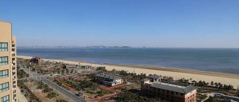 Un paisaje urbano costero con playa, edificios y cielo despejado.