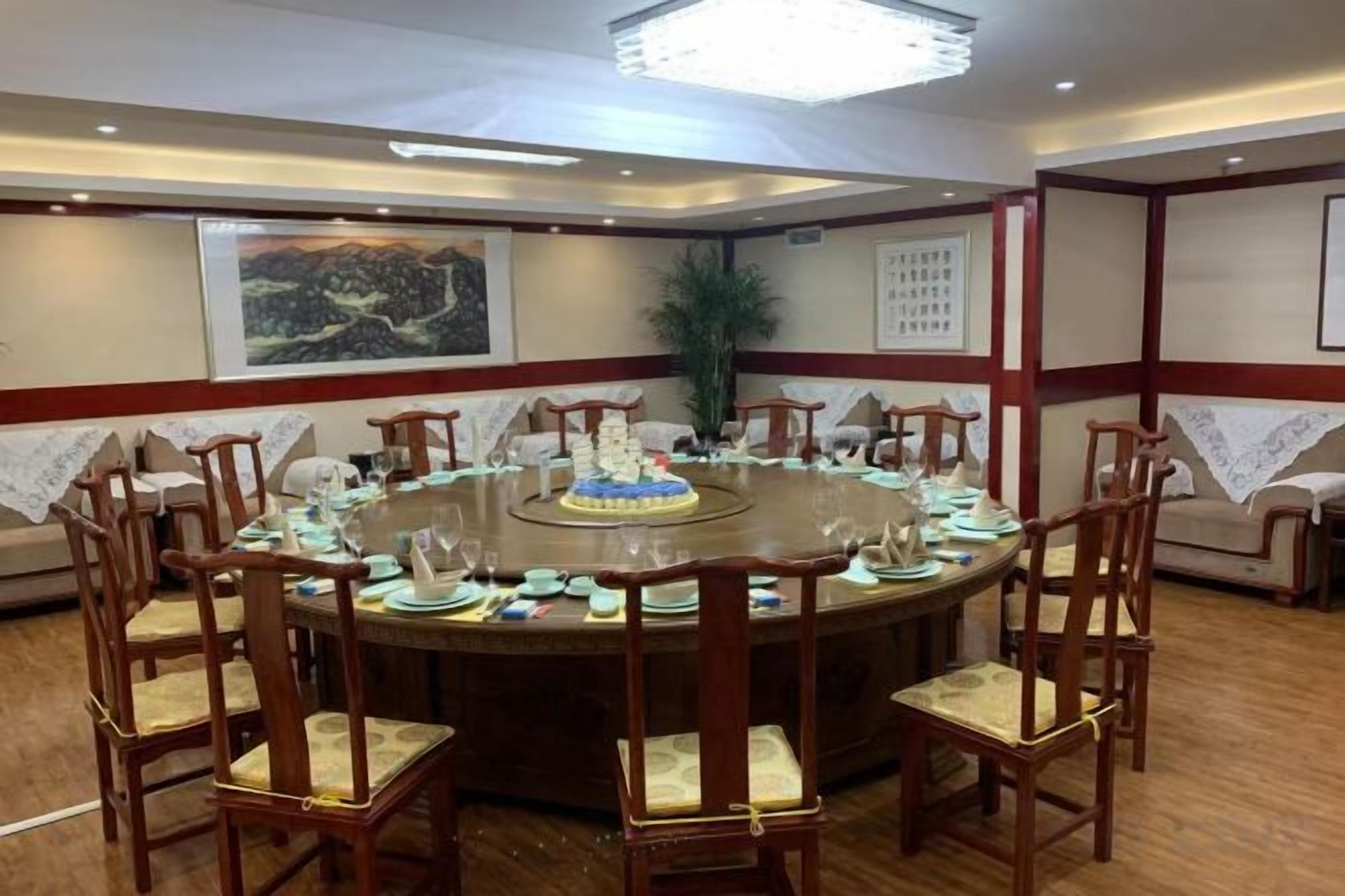 A conference room with a round table, chairs, and a cake.