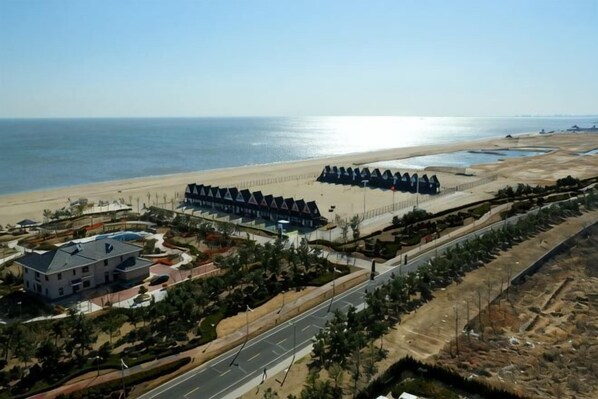 Un hôtel situé sur la côte, avec vue sur la plage, un parking et un jardin aménagé.