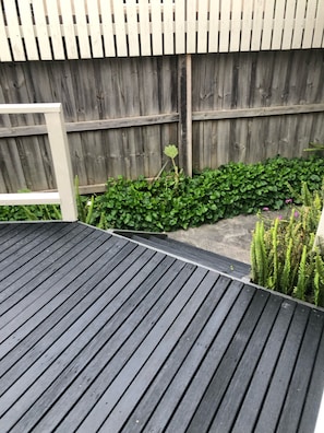 Enjoy an outdoor space with a wooden deck and lush green surroundings.
