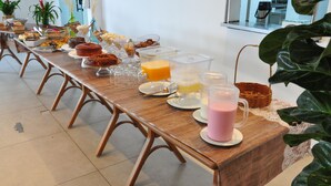 Mesa de buffet com diversos alimentos e bebidas.
