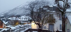 Un village enneigé, avec des bâtiments et une montagne en arrière-plan.