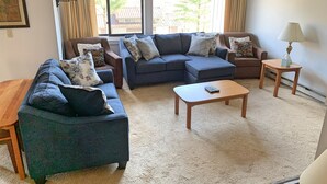 A living room with a sectional sofa, a coffee table, and two side tables.