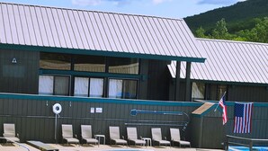 A swimming pool with lounge chairs and an American flag.