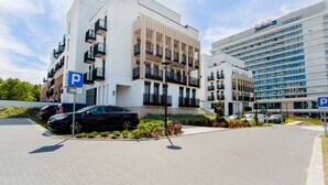 Moderni hotelli, jossa on pysäköintialue, useita kerroksia ja parvekkeita.