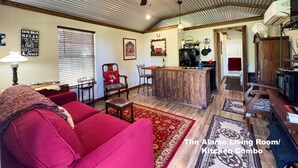 Ein Wohnzimmer mit rotem Sofa, Couchtisch aus Holz und Deckenventilator.