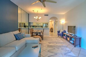 Relax in this stylish living space with a large sofa, coffee table, and dining area.