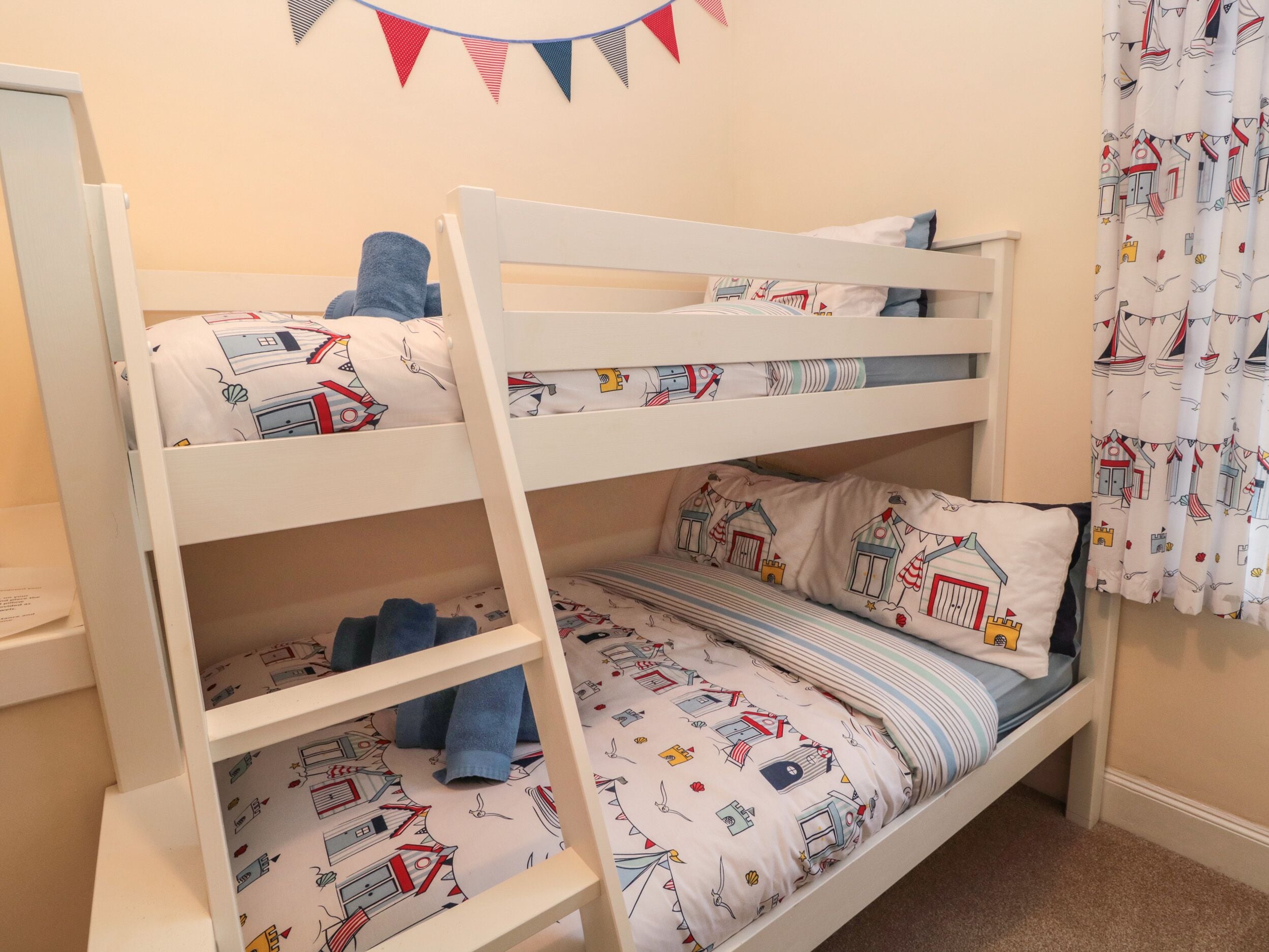 A bunk bed with two levels, each with a pillow and a blanket.