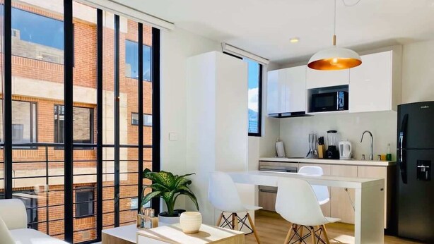 Un apartamento moderno con cocina, comedor y sala de estar.