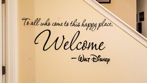 A staircase with a welcoming sign that reads "To all who come to this happy place, Welcome - Walt Disney."
